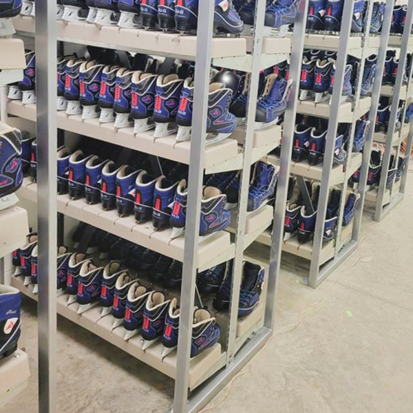 American Athletic rental ice skates displayed on a floor-mounted rack